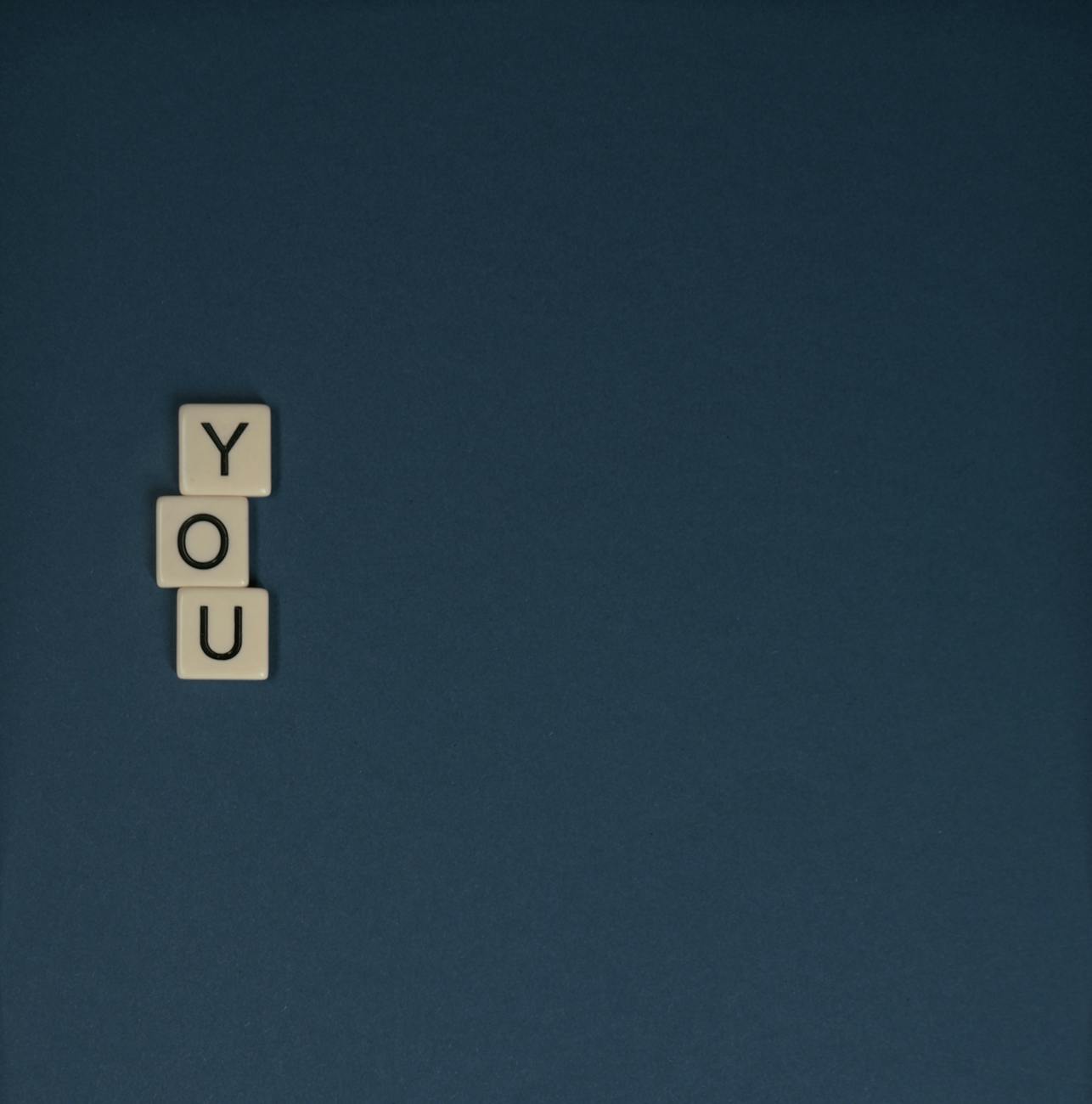 scrabble tiles on blue surface